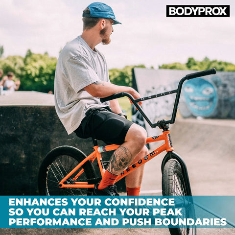 Man wearing Gnarly Protective Padded Shorts For Snowboard, Skate And Skiing with BMX bike at skatepark.