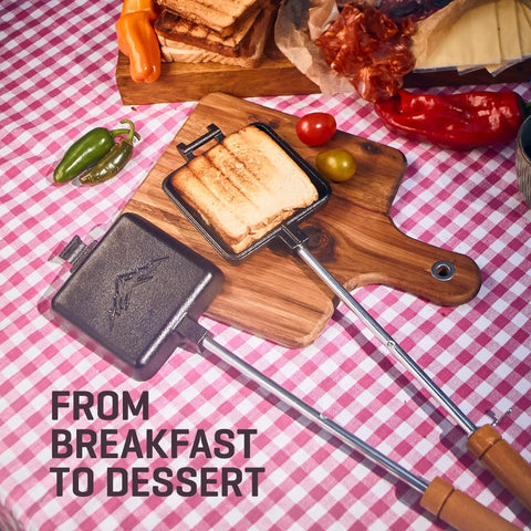 Cast Iron Pudgy Pie Maker for Campfire and Outdoors with toasted sandwich and wooden handle on checked tablecloth