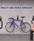 Heavy Duty 150 Foot Hose Hanger With Rust Resistant Metal Wall Mount Organizer installed in a garage with bike and accessories