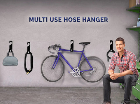 Heavy Duty 150 Foot Hose Hanger With Rust Resistant Metal Wall Mount Organizer installed in a garage with bike and accessories