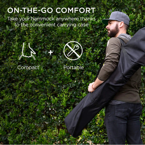 Man carrying Two Person Outdoor Hammock With Spreader Bars And Cotton Rope, Backyard Patio Lounger in a case, 450 Pound Weight Capacity