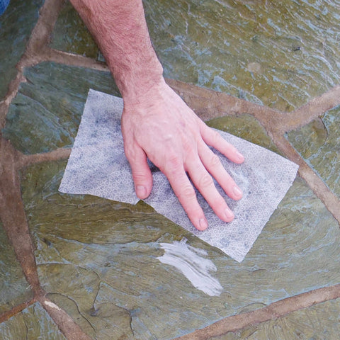 Hand wiping stone surface with Heavy Duty Cleaning Wipes For Every Surface And Hands, 90 Count, All Purpose Cleaner.