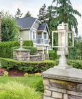Elegant Dusk To Dawn Outdoor Post Light With Pier Mount Base, white weatherproof lantern, auto on off, in garden setting.