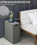 Weatherproof 17.3 Gallon Wicker Storage Box With Slatted Acacia Wood Flip Top For Indoor And Outdoor Use Cushions Pool Gear Garden Tools UV Resistant Gray next to a sofa.
