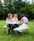 Three children drawing on a Compact Kids Picnic Table With Foldable Benches Under The Table And Built In Carry Handle For Easy Transport