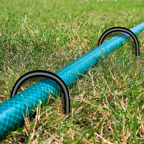 Heavy Duty U Shaped Trampoline Anchors 8 Pack Ground Stakes securing hose in grassy yard, zinc plated steel