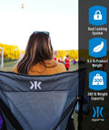 Back view of woman sitting in Versatile Folding Outdoor Chair For Camping And Lawn With Dual Lock System in Hallet Peak Gray.