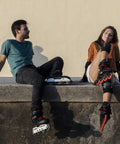 Two people with inline skates sitting on a ledge, showcasing leisure and skill in skating.