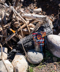 Pack of Fire Balls Fire Starter Pellets for Easy Fire Lighting, 7 Minute Burn Time, next to a campfire setting with rocks and logs.