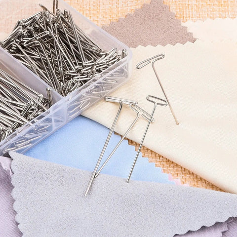 Heavy Duty Stainless Steel T Pins For Blocking And Knitting in a clear storage case with assorted fabric swatches.
