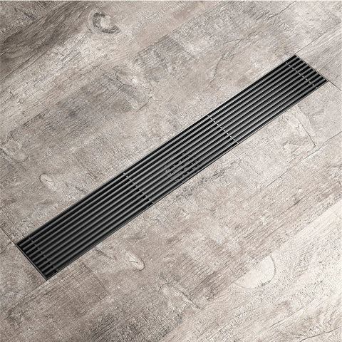 Total Upgrade Linear Shower Drain In Stainless Steel With Removable Grate And Efficient Hair Catcher For Flawless Smooth Draining No Clogs Nonsense For Your Dream Bathroom Rose Gold on grey floor.