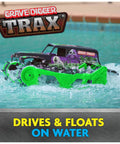 Grave Digger Trax All Terrain Remote Control Vehicle driving on water with tank treads, showcasing its water-friendly design.
