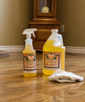 Orange Oil Wood Cleaner And Polish Spray For All Wood Surfaces Restorer And Conditioner, shown in gallon and spray bottle on floor