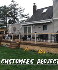 26 Inch Hollow Round Iron Deck Balusters Matte Black in a customer's outdoor railing project with wooden deck and plants.