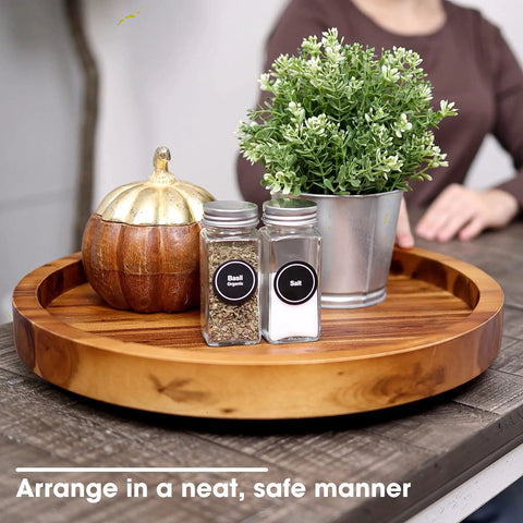 Slick 13 Inch Acacia Wood Lazy Susan Turntable Organizer For Kitchen Cabinets displaying spices and greenery on a smooth circular tray.