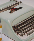Typewriter Oil That Fixes Sticky Keys With 100 Percent Synthetic Formula, Delivers Smoother, Quieter Keys, Odor Free, Displaces Old Petro Oils, Quickly Clears Gunk, Includes 1/2 Inch and 1-1/2 Inch Needles For Easy, Mess Free Application, bottle with needle next to vintage typewriter