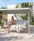 Woman seated on 3 To 4 Person Outdoor Patio Swing With Canopy, 2 In 1 Swing Bed, Adjustable Backrest, 800 Lb Capacity, Porch Swing With Stand