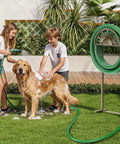 Children washing a dog with Freestanding Garden Hose Reel Stand With Storage Basket And Two Hooks, Holds 150 Ft Of 5/8 Inch Hose