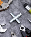 4 Way Sillcock Water Key Set 2 Pack Heavy Duty Steel Cross Wrench on concrete surface among various hand tools