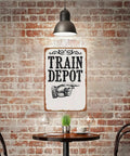Train Depot Aluminum Wall Decor 12x8 Inch sign in cafe setting with exposed brick wall and metal furniture.