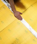 Premium Flooring Underlayment Roll 100 Sq Ft 2Mm Thick with pre-taped sides, showing a hand laying the grid cut design.