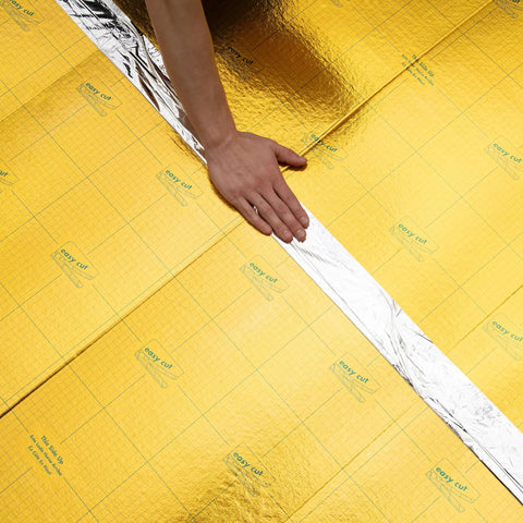 Premium Flooring Underlayment Roll 100 Sq Ft 2Mm Thick with pre-taped sides, showing a hand laying the grid cut design.