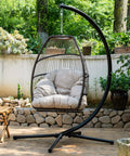 Cozy Outdoor Hanging Egg Chair With Stand And UV Resistant Cushion in garden setting, durable swing seat for relaxation.