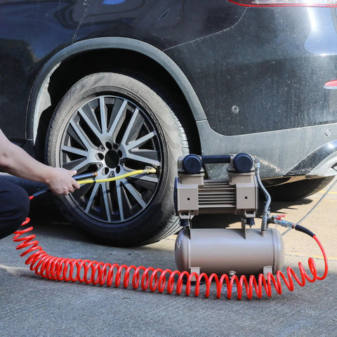 1/4 In X 30 Ft Polyurethane Recoil Air Hose With Bend Restrictors in use, connecting air tool to vehicle tire, red coiled hose visible