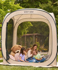 Family inside Pop Up Screen Tent With Carry Bag 6 By 6 Feet Portable Screen Room Canopy For Patio Backyard Deck And Outdoor Use Bug Proof Mosquito Netting Ventilated 4 Sided Mesh For Fresh Air And Bug Free Gatherings Beige, surrounded by greenery.