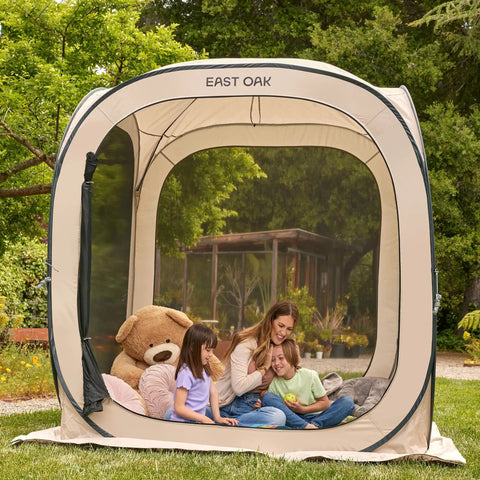 Family inside Pop Up Screen Tent With Carry Bag 6 By 6 Feet Portable Screen Room Canopy For Patio Backyard Deck And Outdoor Use Bug Proof Mosquito Netting Ventilated 4 Sided Mesh For Fresh Air And Bug Free Gatherings Beige, surrounded by greenery.