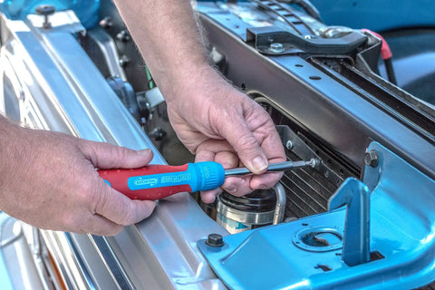 Using 13 In 1 Ratcheting Multi Bit Screwdriver With Quick Load Cushion Grip 28 Tooth Ratchet on car engine, close-up