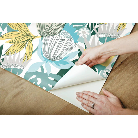 Teal And Yellow Retro Tropical Leaves Peel And Stick Wallpaper Roll For Accent Walls Dope Vibe being installed on wooden surface