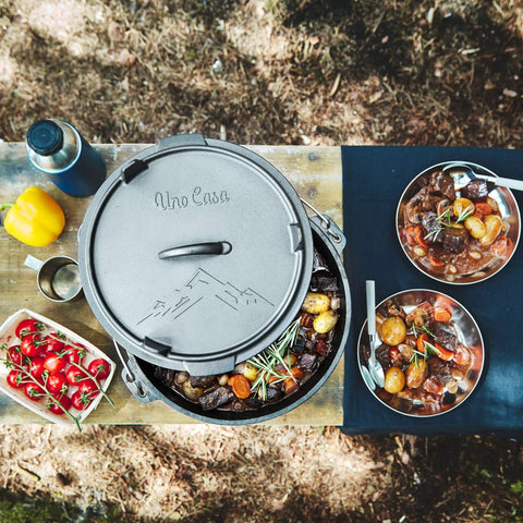 Six Quart Cast Iron Camping Dutch Oven With Lid Lifter And Storage Bag For Campfire Cooking Stews And Baking Durable Pre Seasoned Outdoor Pot For Camping And Hiking on table with cooked stew