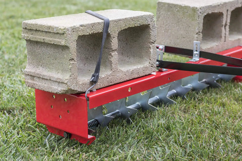 36-Inch Tow-Behind Spike Aerator for Lawns with 9 Galvanized Disks and an 80 lb Weight Tray on grass