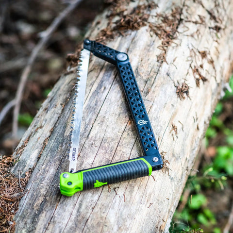 Folding Camp Saw With 12 Inch Blade For Backpacking, Hiking, Camping And Bushcraft, bright green accents on log