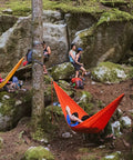 Outdoor scene with campers using Roo Double Hammock With GravitasX Water Resistant Breathable Ripstop Fabric in a forest setting.