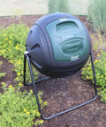 Ms Tumbles 35 Gallon Compost Tumbler With Easy Turn System in black and green, installed in a garden setting