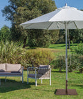Patio scene with heavy duty 50 lb patio umbrella base, 24 inch square holder, two tightening knobs, wheels, weatherproof steel brown.