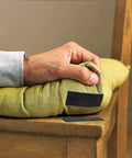 Hand applying Beefy Black Scotch Extreme Fasteners 10 Ft By 1 In Heavy Duty Velcro Bond on a chair cushion, weatherproof and UV resistant.