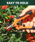 Hand holding orange garden pruning shear from Three Pack Garden Pruning Shears Set With Stainless Steel Blades, cutting branches.