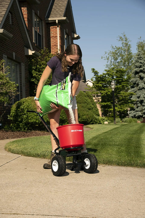 Person using 2600A-PLUS Fertilizer Spreader With 40Lb Hopper Capacity, Rust-Proof Polypropylene Body on a lawn