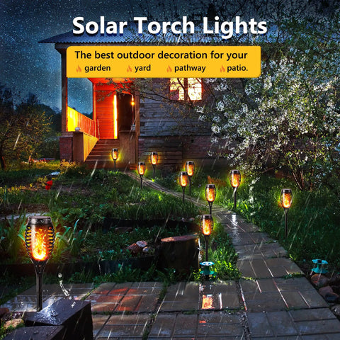 12 Pack Solar Torch Lights With Flickering Flames For Outdoor Use illuminating a garden path and patio at night.