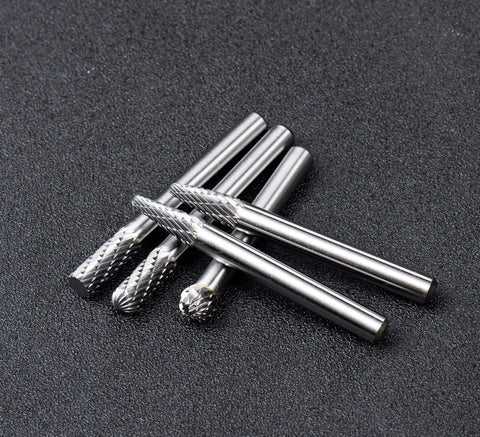 Carbide burr set for metalwork shown in close-up, featuring five solid carbide rotary burr tools with a quarter-inch shank for precision tasks.