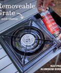 Portable Camping Stove With Carry Case And InstaStart Ignition showing butane canister being installed next to removable grate.