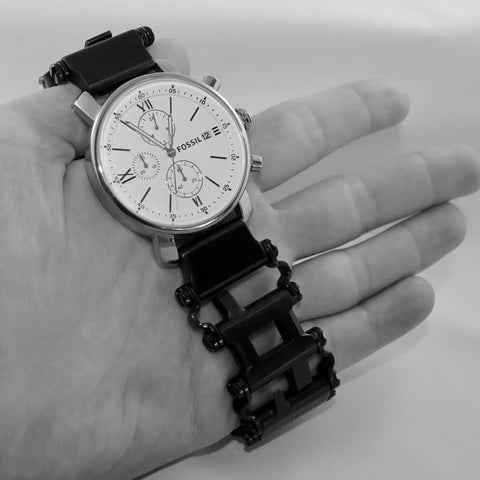 Watch Adapters for Tread and Tread LT in Black 16mm Lug Size Includes Pin Tool and Replacement Pins Lets You Swap Watch Bands Fast Apple Watch Compatible Adapters Patent Pending, displayed with a silver watch and black adapter in hand.