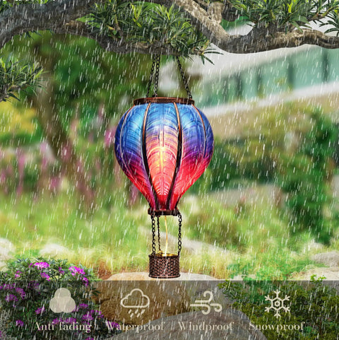 Blue Purple Hot Air Balloon Solar Lantern for garden decor hanging from tree in rain, lit flickering flame outdoor light.