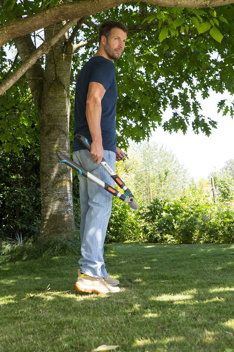Man holding Heavy-Duty Tree Loppers With Steel Blade And 35.5 Inch Handle, Telescoping TeleCut 650-900 B Pruner For Cutting Green Branches And Shrubs, Extend Reach For High Limbs, A True Workhorse And Cuts Up To 1.65 Inches, German Made in garden