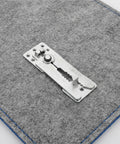 Close-up of a Top Shelf Stainless Steel Sectional Couch Connector Built Tough With Anti Slip Grip on gray fabric surface.