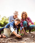 Family planting in a garden with watering can and pots