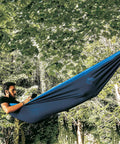 Person lounging in Double Travel Hammock Ultralight Parachute Nylon With Breathable Fabric in forest setting